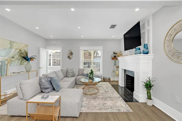 a living room with furniture a flat screen tv and a fireplace
