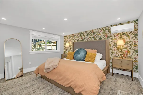 a bedroom with a bed and a painting on the wall