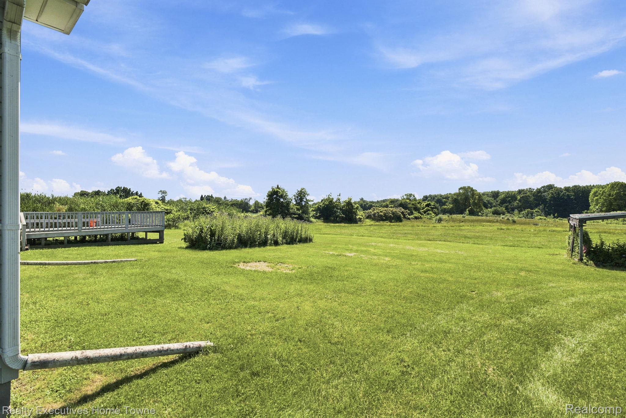 959 Braidwood Road Memphis, MI 48041 - Photo 49 of 58 Expansive green lawn with a raised wooden deck featuring railing