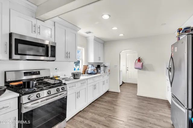 a kitchen with stainless steel appliances a stove microwave and refrigerator