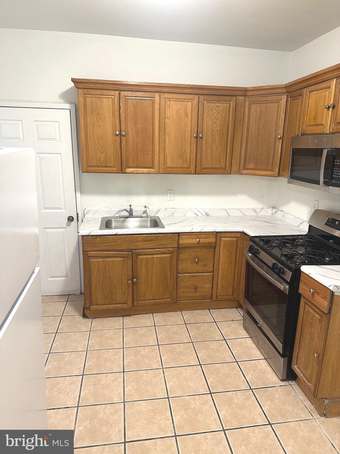 2826 Cedar Street Philadelphia, PA 19134 - Photo 2 of 8 a kitchen with stainless steel appliances granite countertop a sink stove and cabinets