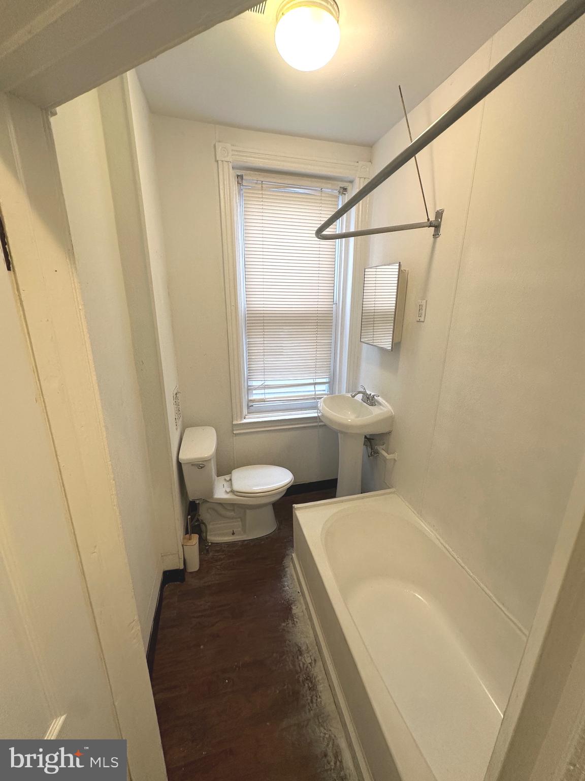 2826 Cedar Street Philadelphia, PA 19134 - Photo 8 of 8 a bathroom with a sink a toilet a window and a mirror
