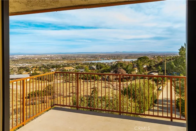 a view of a big room with windows and chandelier fan