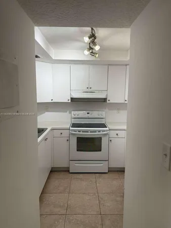 a kitchen with white cabinets and appliances