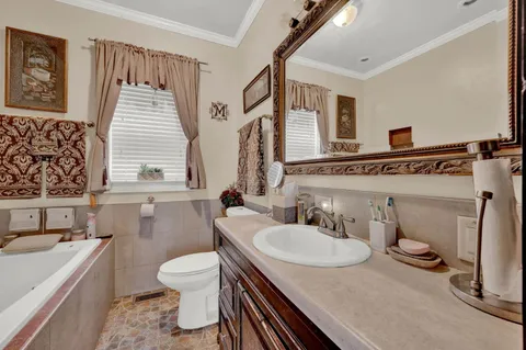 a bathroom with a granite countertop sink toilet a mirror and bathtub
