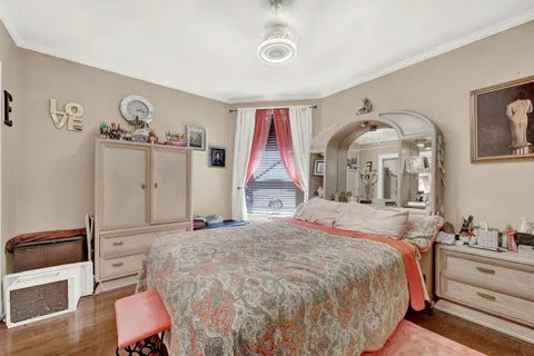 a bedroom with a bed and a large mirror on the dresser