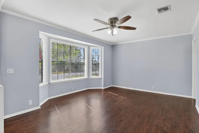a view of a big room with wooden floor closet and windows