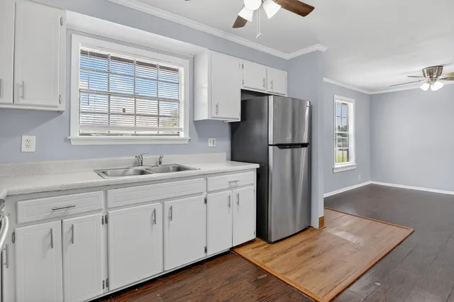 a kitchen with white cabinets and refrigerator