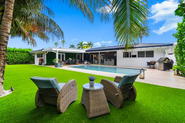 a view of a house with a swimming pool and sitting area