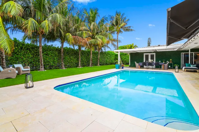 a swimming pool with outdoor seating and yard