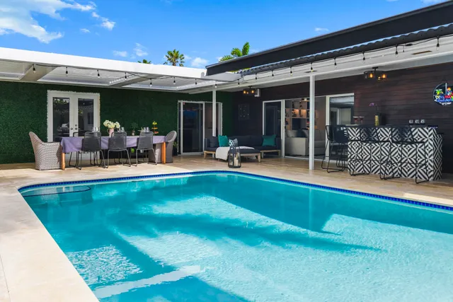 a view of a house with swimming pool and sitting area