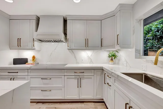 a kitchen with white cabinets and a sink