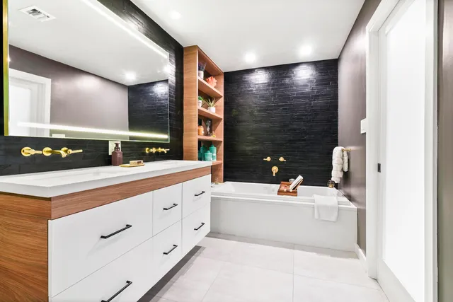 a bathroom with a tub sink and mirror