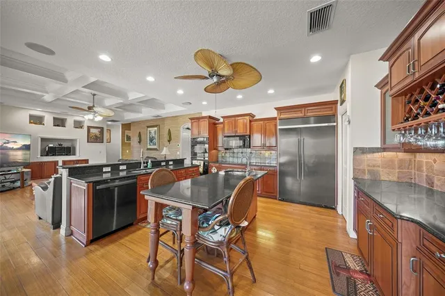 a kitchen with stainless steel appliances granite countertop a sink stove and refrigerator