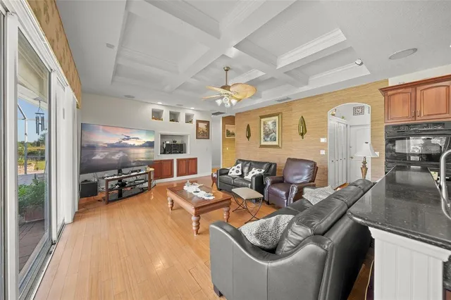 a living room with furniture a ceiling fan and a large window