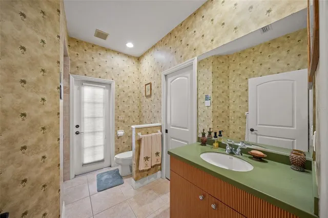 a en suite bathroom with a granite countertop sink and a mirror