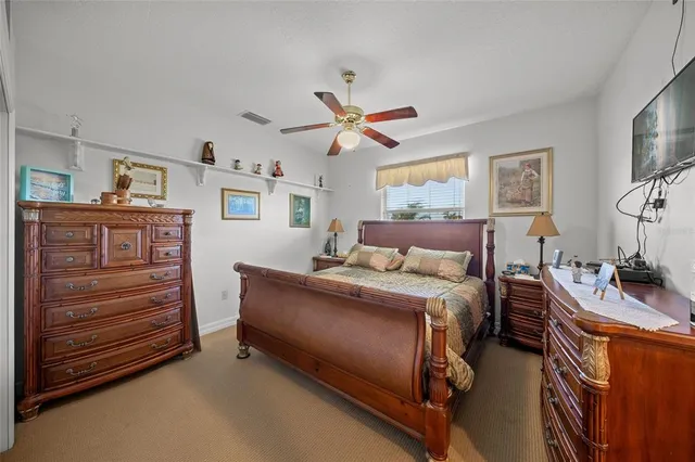 a bedroom with a bed dresser and a flat tv screen