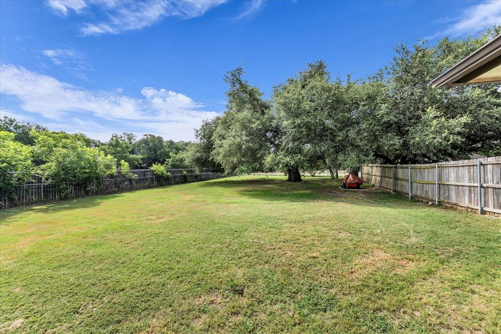 7 Market Loop Morgan's Point Resort, TX 76513 - Photo 26 of 31 Expansive green lawn with mature trees and a wood privacy fence