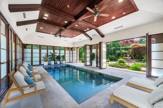 a swimming pool with large glass windows and painted walls