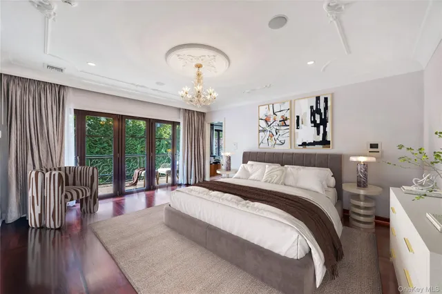 a spacious bedroom with a large bed and a chandelier