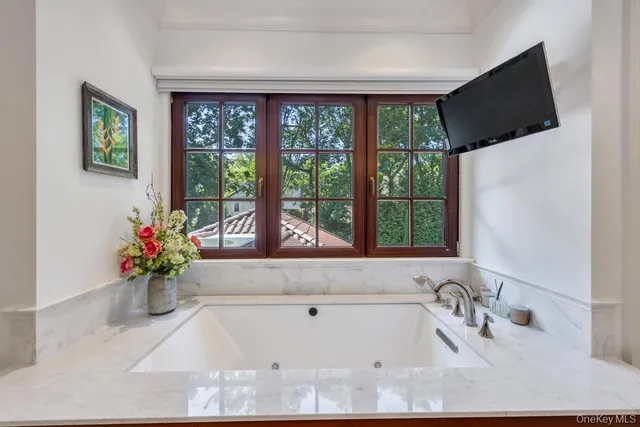 a white bath tub sitting in a bathroom next to a window