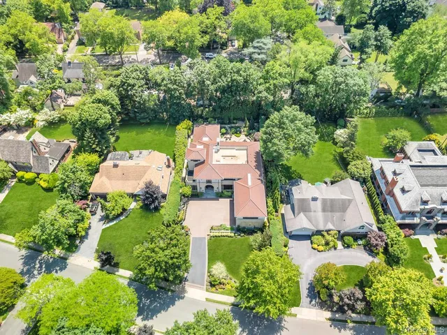 an aerial view of a house with a garden and lake view