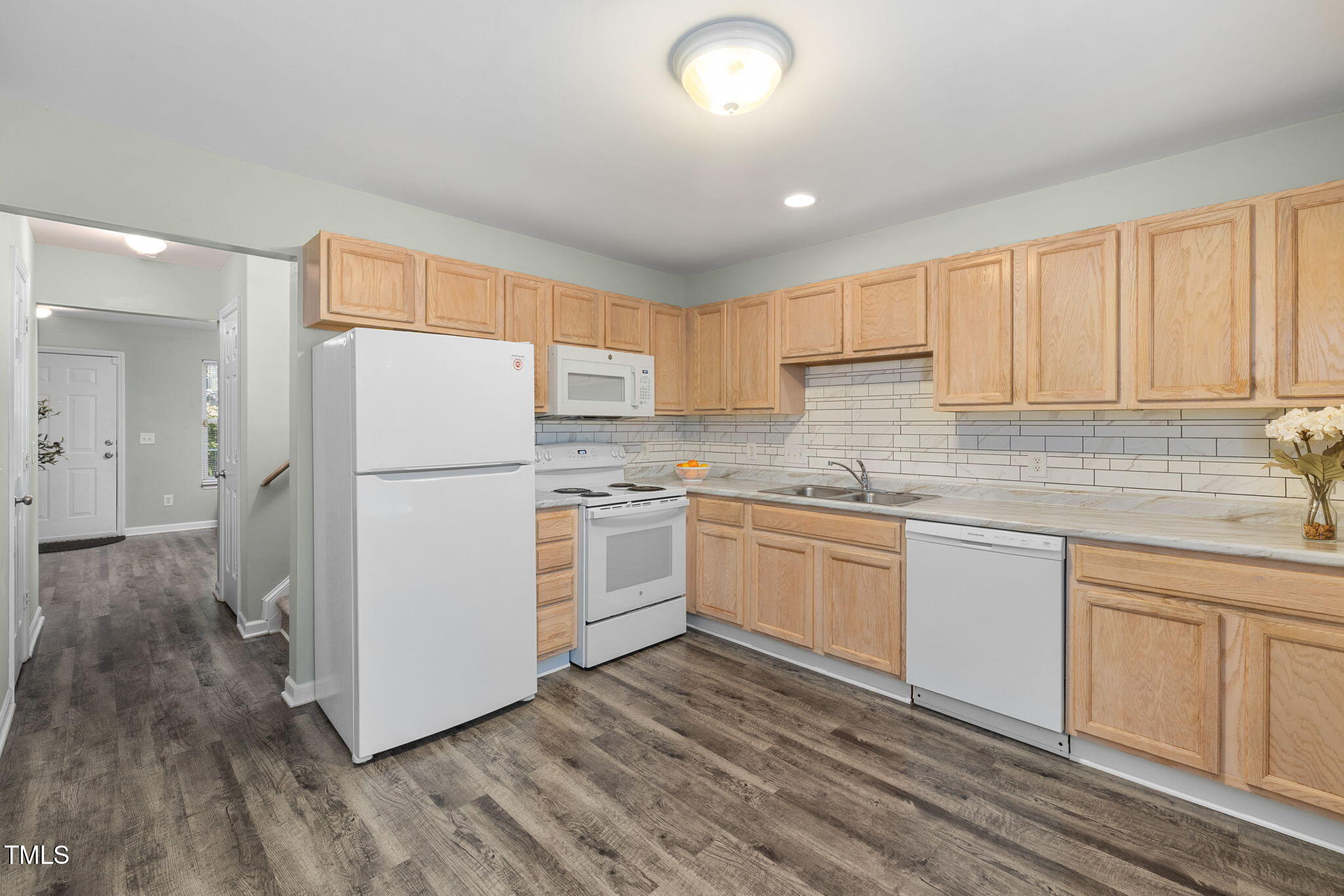 67 Red Lane Raleigh, NC 27606 - Photo 7 of 33 a kitchen with a refrigerator a stove top oven a sink and cabinets