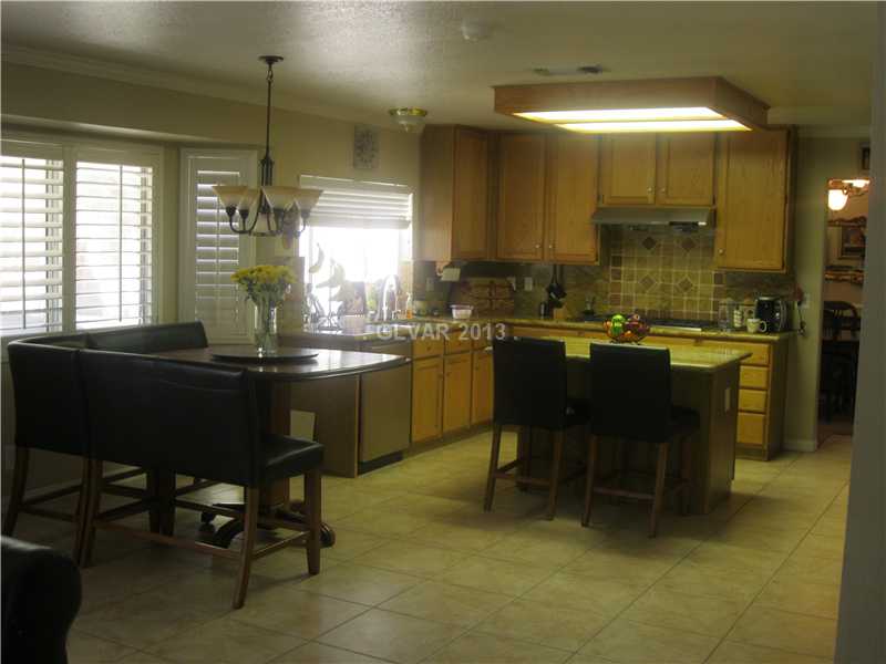 2037 Shadow Brook Way Henderson, NV 89074 - Photo 10 of 34 Kitchen. KITCHEN WITH SS APPL, BAY WINDOW, LARGE ISLAND, CUSTOM TILE BACKSPLASH, LARGE WALK IN PANTRY ON RIGHT.