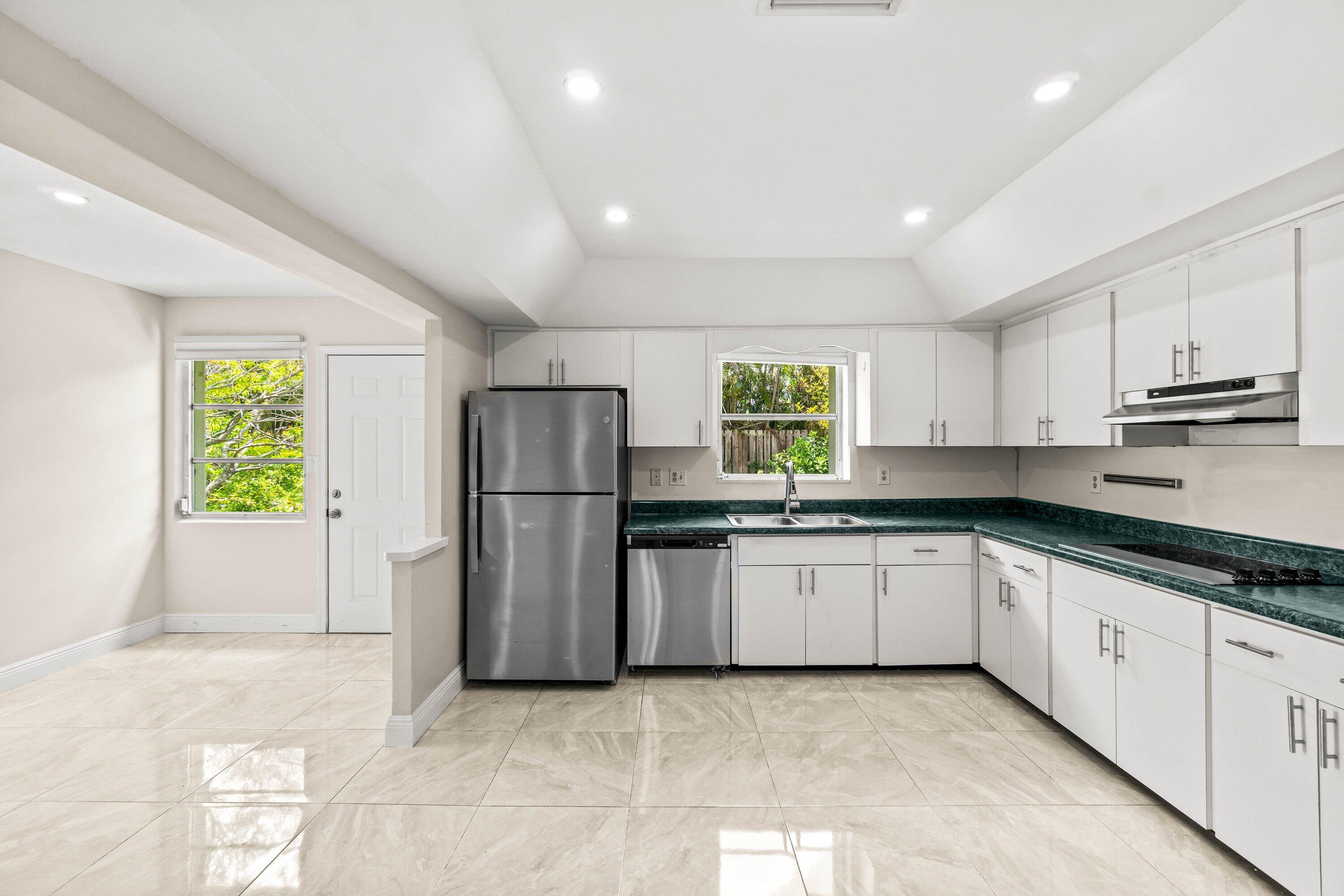 1290 Southwest 8th Street Boca Raton, FL 33486 - Photo 5 of 29 a kitchen with stainless steel appliances granite countertop a refrigerator sink and stove