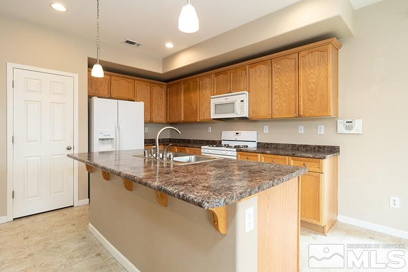 2010 Long Hollow Drive Reno, NV 89521 - Photo 8 of 24 a kitchen with stainless steel appliances granite countertop a sink stove and refrigerator