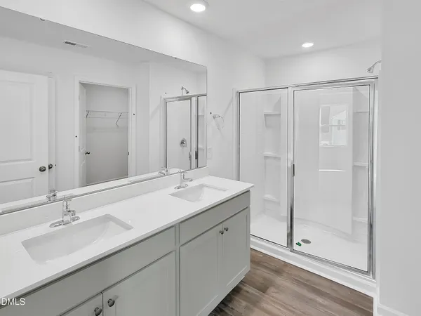 a bathroom with a double vanity sink toilet mirror and bathtub