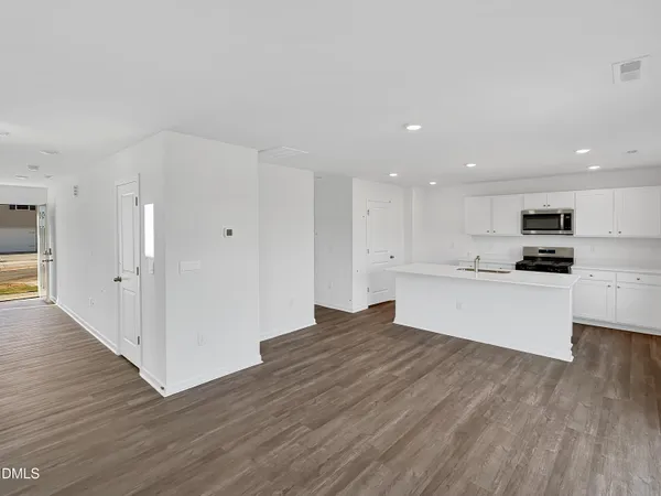 a kitchen with white cabinets and appliances