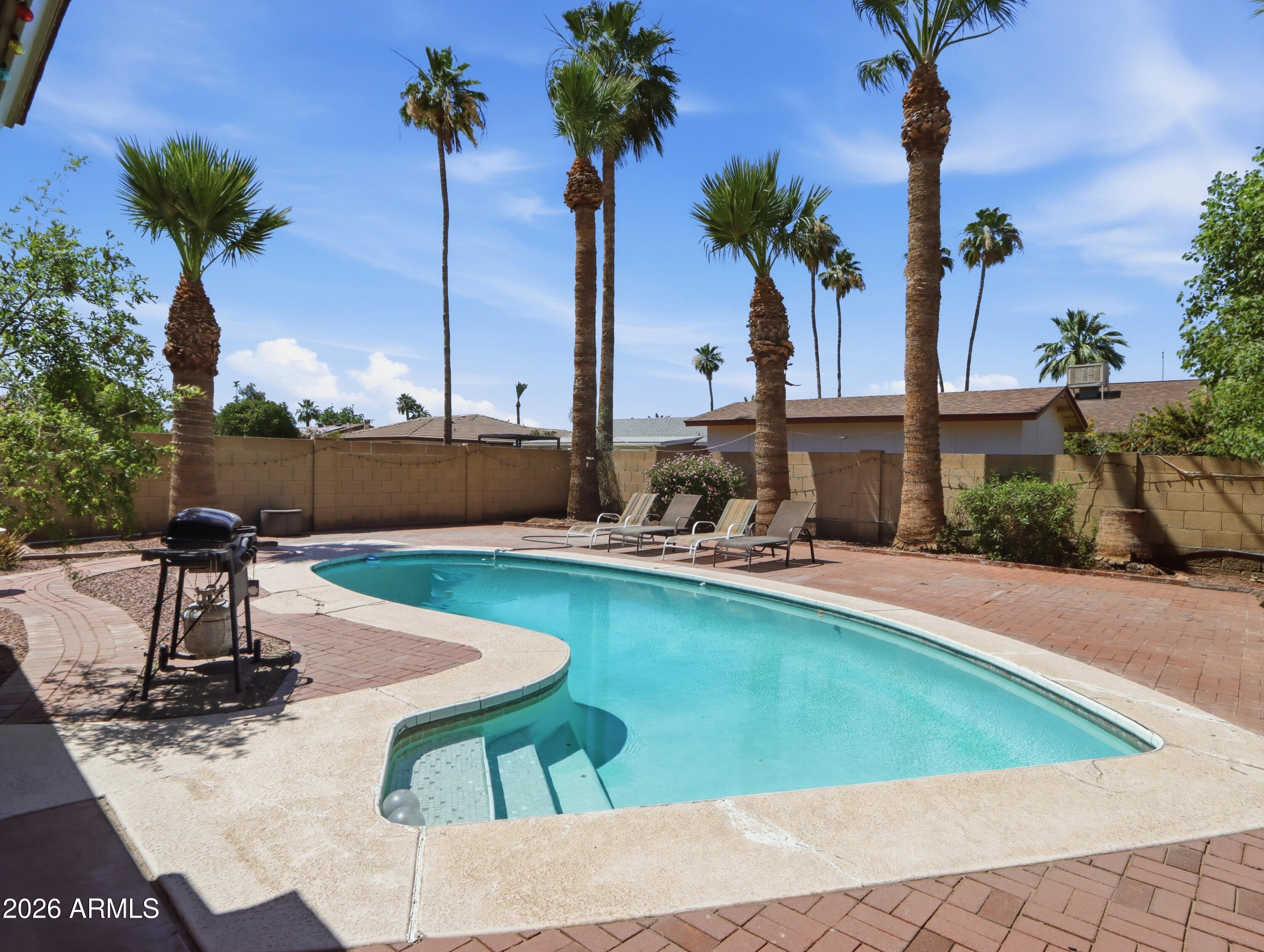 450 Cascada Road Litchfield Park, AZ 85340 - Photo 26 of 40 a view of a swimming pool with a table and chairs