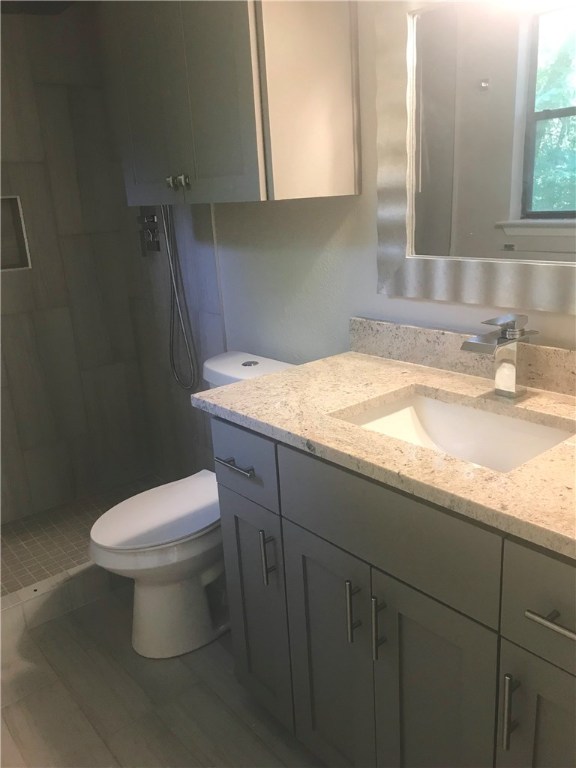 1610 Waterloo Trail, Unit B Austin, TX 78704 - Photo 18 of 23 a bathroom with a granite countertop toilet sink and mirror