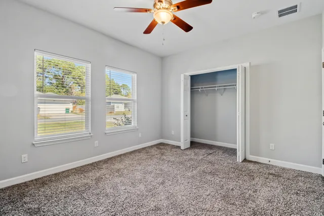 an empty room with a window and a fan