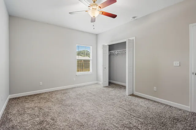 an empty room with a window and a fan