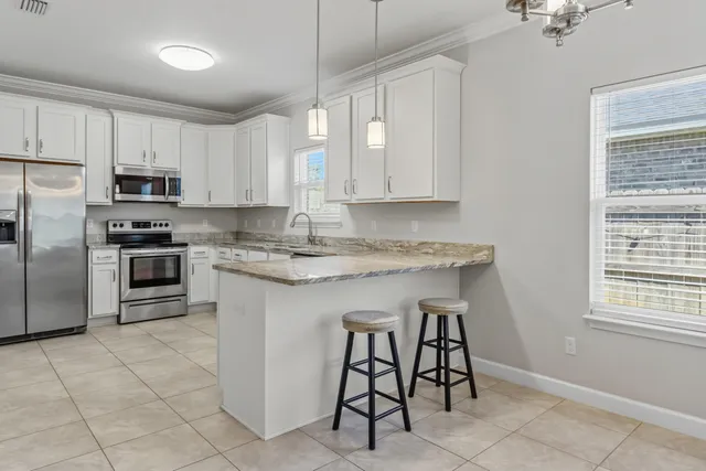 a kitchen with stainless steel appliances granite countertop a sink and a refrigerator