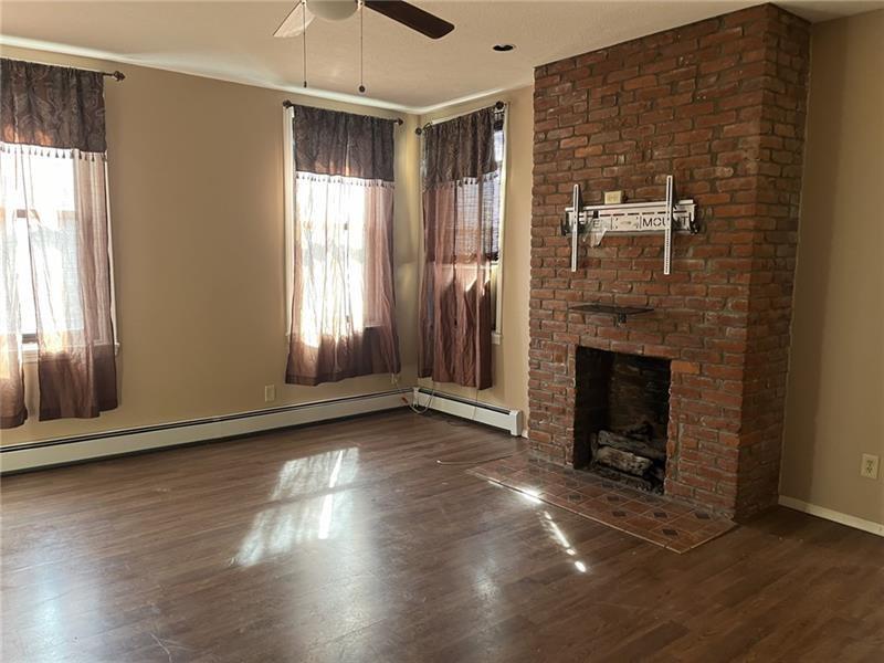 2515 Mt Troy Road Pittsburgh, PA 15212 - Photo 9 of 27 an empty room with wooden floor fireplace and windows