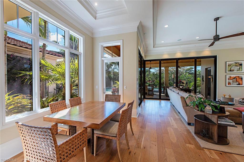 2178 Miramonte Way Naples, FL 34105 - Photo 5 of 21 a view of a dining room with furniture large windows and wooden floor