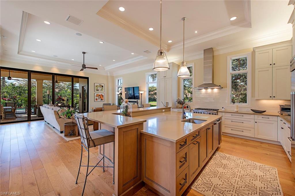 2178 Miramonte Way Naples, FL 34105 - Photo 7 of 21 a large kitchen with kitchen island a large island a sink a stove and a large window
