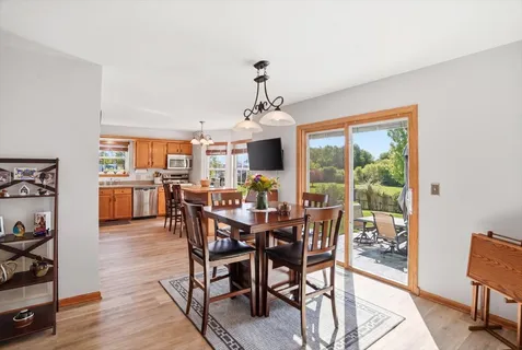 a dining room with furniture a chandelier and wooden floor