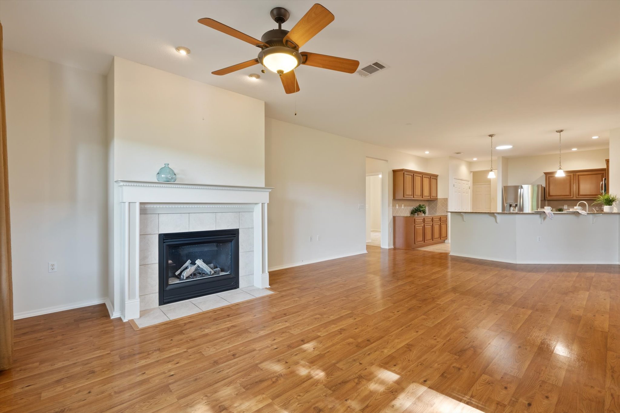 126 Trail Rider Way Georgetown, TX 78633 - Photo 9 of 30 a view of a livingroom with a fireplace a ceiling fan and kitchen view