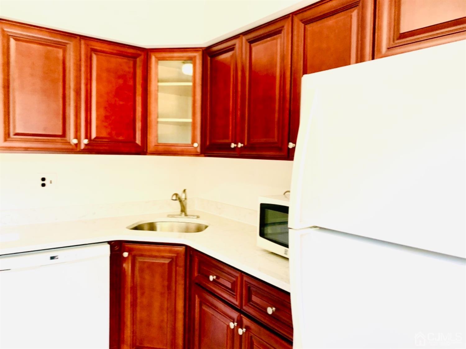 8401 Hana Road Edison, NJ 08817 - Photo 16 of 41 a kitchen with a refrigerator and cabinets