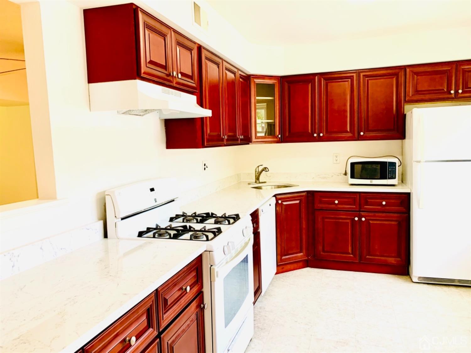 8401 Hana Road Edison, NJ 08817 - Photo 20 of 41 a kitchen with stainless steel appliances a stove a sink and a refrigerator