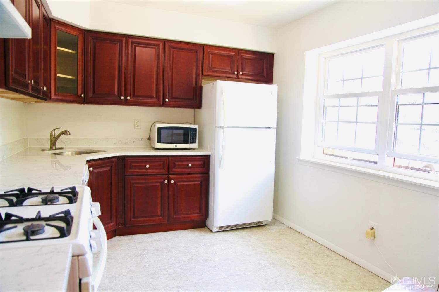 8401 Hana Road Edison, NJ 08817 - Photo 5 of 41 a kitchen with a refrigerator and a stove