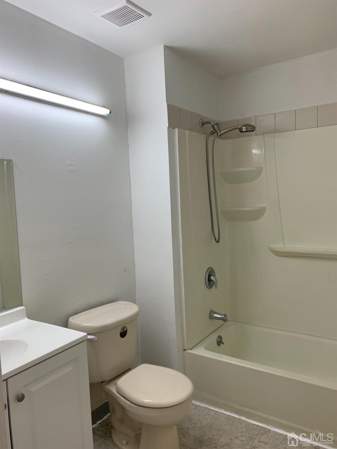 8401 Hana Road Edison, NJ 08817 - Photo 41 of 41 a white toilet and tub next to a bathroom sink