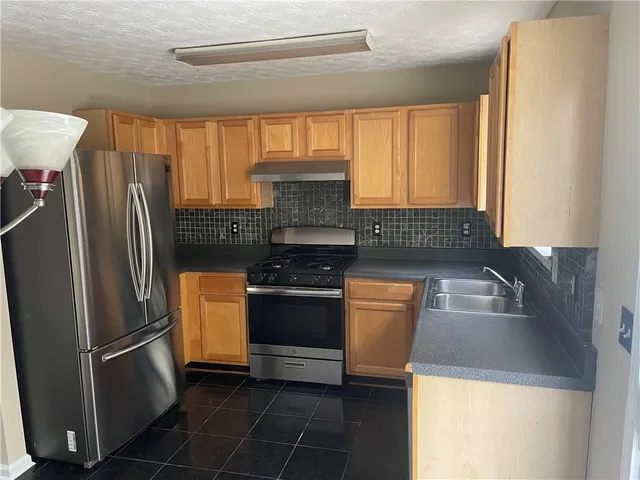 a kitchen with a refrigerator and a sink