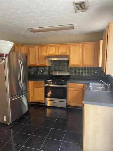 a kitchen with granite countertop a refrigerator and a sink
