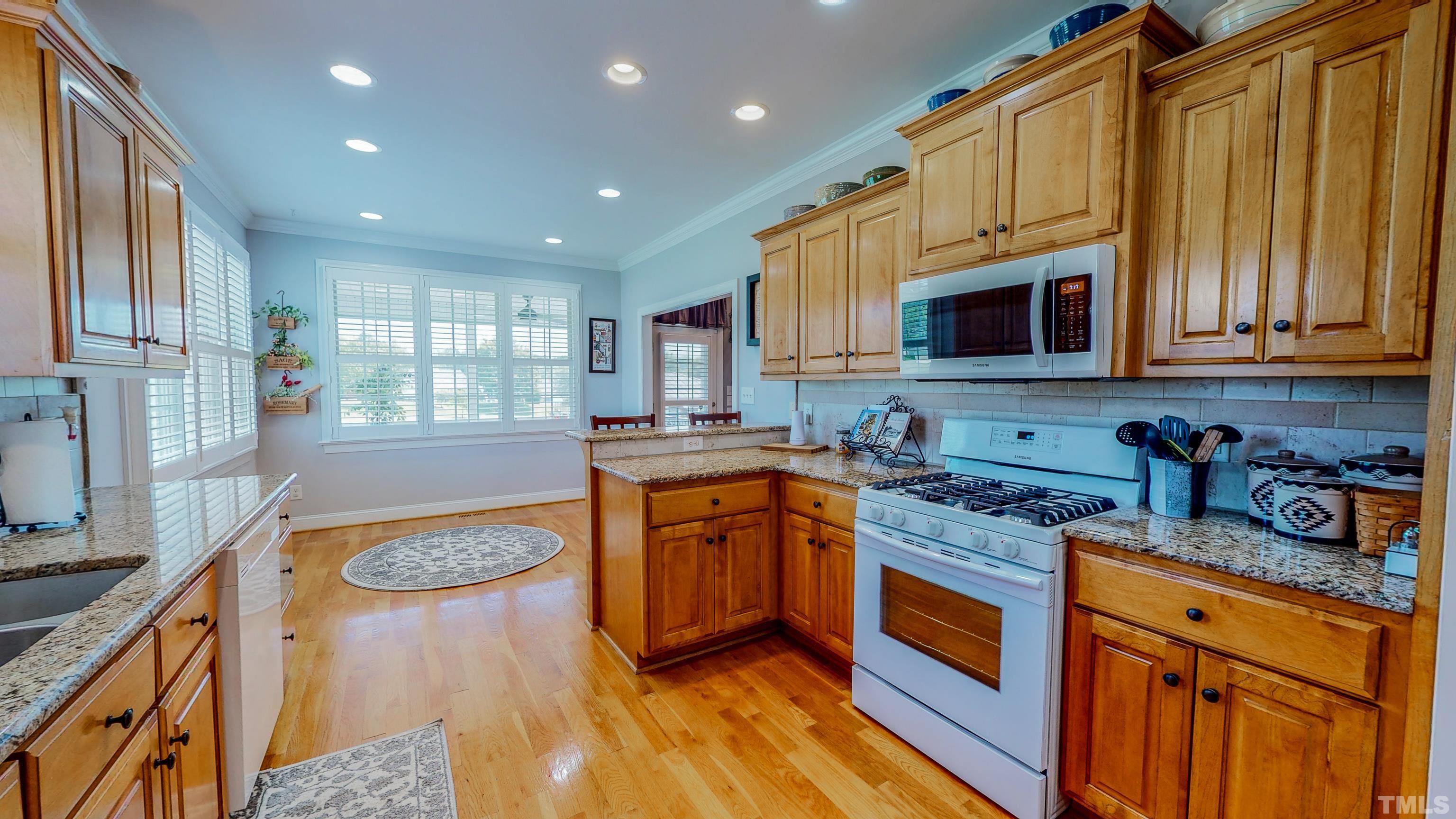 103 Derwin Drive Timberlake, NC 27583 - Photo 13 of 57 a kitchen with stainless steel appliances granite countertop wooden cabinets a stove top oven a sink and dishwasher