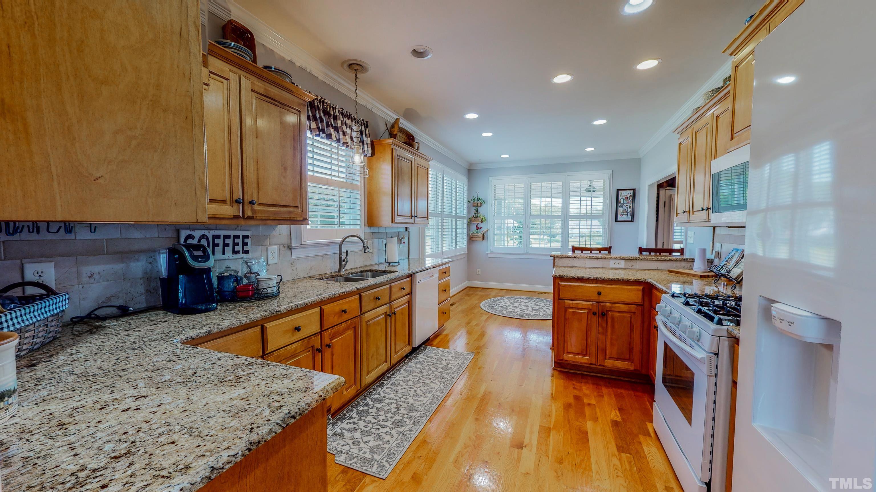 103 Derwin Drive Timberlake, NC 27583 - Photo 14 of 57 a large kitchen with stainless steel appliances granite countertop a stove a sink and a refrigerator
